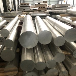 Stack of industrial aluminum rods in warehouse.