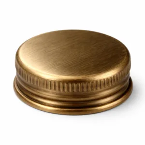 A single antique brass bottle cap with a brushed finish and subtly rounded edge, photographed in a high realism, studio-lit setting with sharp details. Suitable as a functional and stylish accessory for bottles.