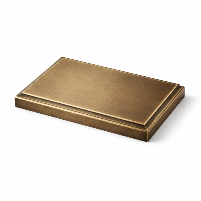 A rectangular metal lid with an antique brass finish, crafted with a flat top, crisp beveled edge, and an unbranded emblem in the center. Industrial yet elegant, perfect for custom container projects.