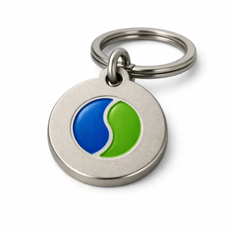 A round-shaped zinc alloy metal tag with a matte nickel finish and subtle sandblasted surface texture. The cut-out logo area is enhanced with soft enamel color fill. Comes attached to a split ring; ideal for keys or accessories.