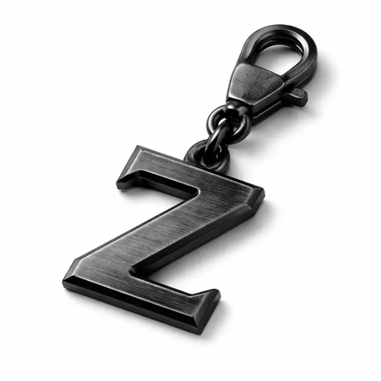 This Cut-Out Letter Zipper Pull simulates stainless steel, finished in matte black nickel with a subtle brushed texture and crisp beveled edge. Styled for contemporary fashion, presented on a white studio backdrop.