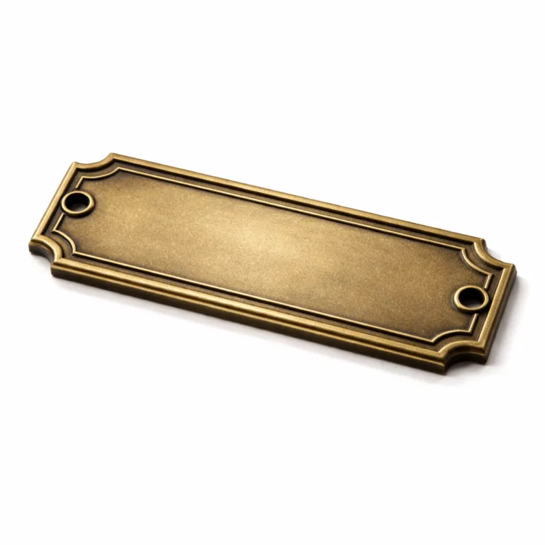 A detailed studio photo of a brass nameplate with an engraved logo, finished in antique brass. The surface is subtly sandblasted for a matte look, and the 2D flat relief design includes screw holes on each end. Captured for an authentic and classic product presentation.