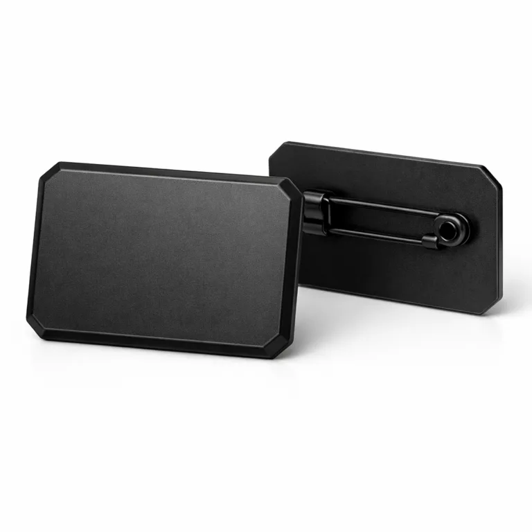 A variant of the matte black electroplated badge in a flat 2D design with crisp beveled edges and a brass-inspired appearance. The badge features a safety pin back for secure attachment and is presented with high realism for product listings.