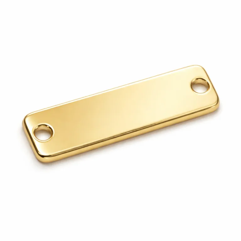 A polished gold mirror-finish garment tag plate with soft rounded edges and two sewing holes, crafted for a premium, luxurious accent to apparel items.