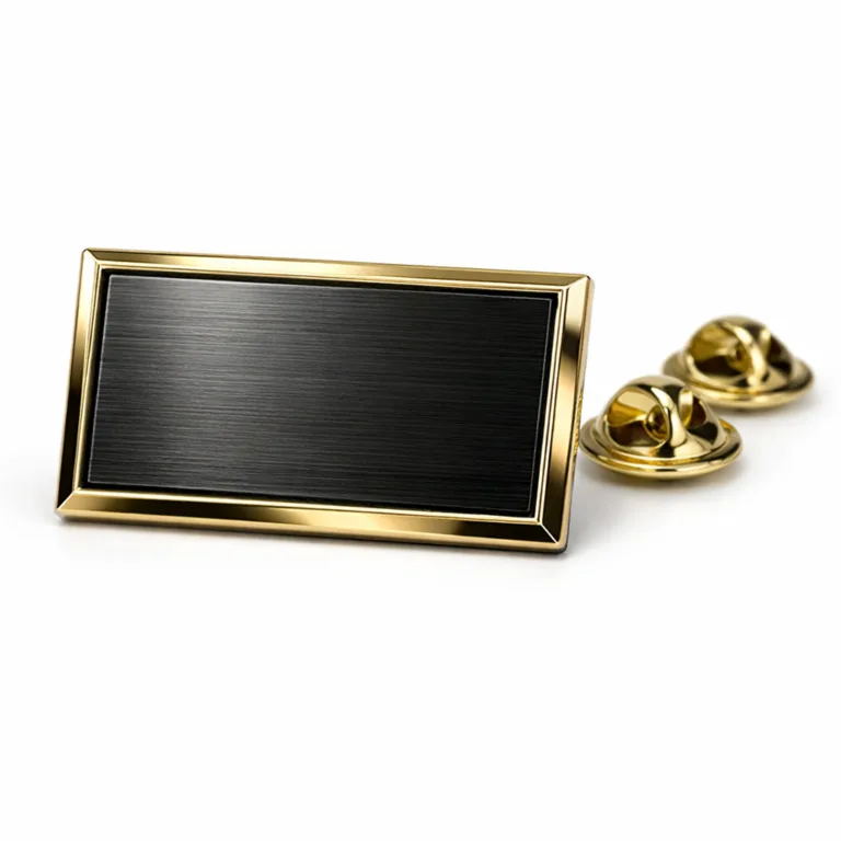 A rectangular two-tone plated badge in black nickel and gold, displaying a stylish brushed metal texture. The design includes crisp beveled edges and a classic butterfly clutch attacher. Premium e-commerce studio photography.