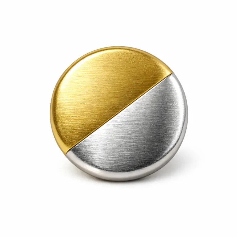 E-commerce studio photograph of a brass two-tone plated fashion button with a brushed matte finish, gold and silver plating, and soft rounded edge. The round shape and realistic details are highlighted under commercial lighting.