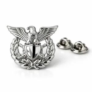 High quality uniform cap badge crafted from zinc alloy, featuring a shiny nickel plated surface with crisp beveled edges. The attachment is a butterfly clutch back, suitable for secure wear. Studio lighting highlights the reflective finish.