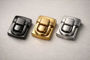 Three luxury hardware samples—zinc alloy, brass, and stainless steel—showcasing finish and craftsmanship differences relevant to premium packaging hardware.