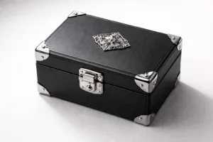 A premium rigid gift box features high-polish zinc alloy hardware including a secure clasp, ornate corners, and a brand logo emblem, enhanced by elegant lighting to showcase texture and finish.