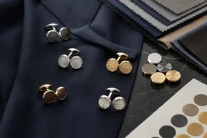 A refined visual showing custom cufflinks placed with formal uniform fabrics and finish references for corporate accessory planning.