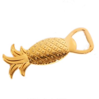 Gold pineapple-shaped bottle opener on white background.