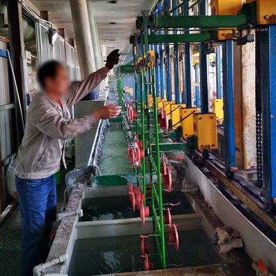 Worker adjusting equipment in industrial water treatment facility.